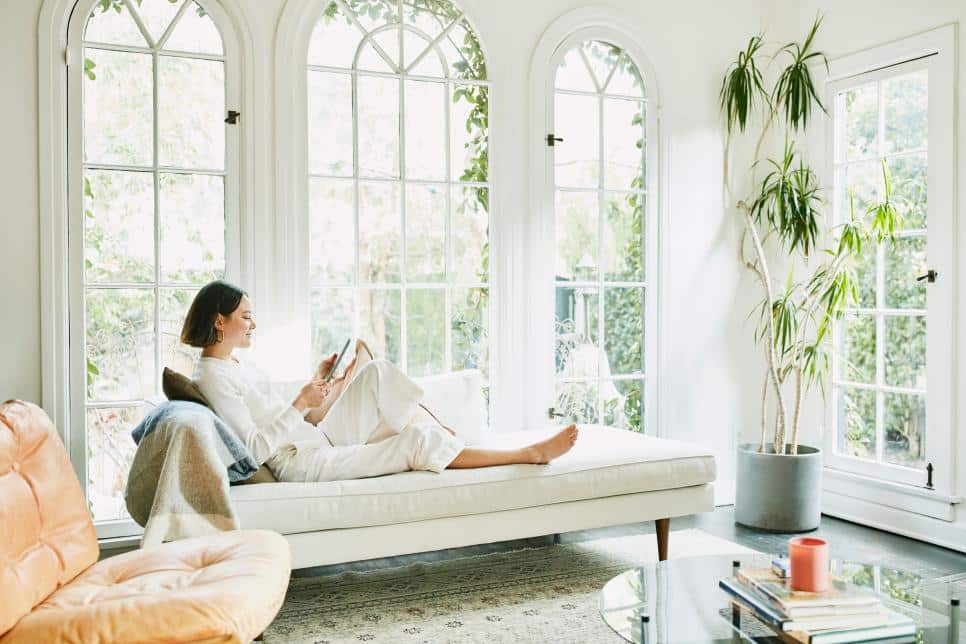 An image of a woman sitting on couch and reading something