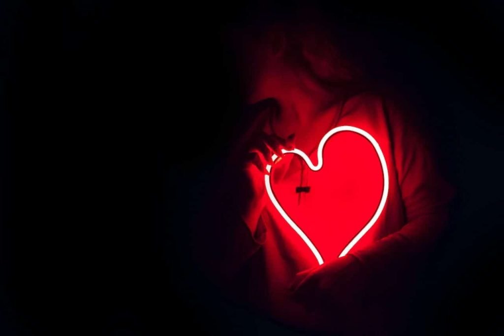 Woman holding a LED-lamp in form of heart