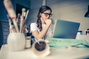 Person looking at Laptop screen with a thoughtful expression